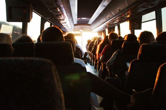 View of seated passengers from the back of the bus