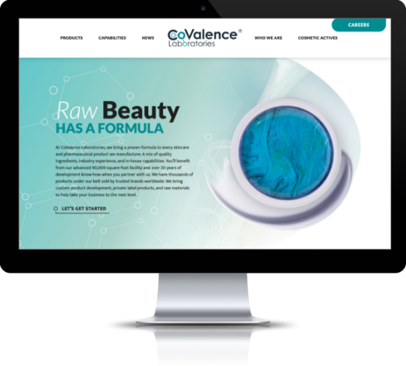 The redesigned homepage for CoValence Laboratories is featured on a desktop computer and has pops of blue with makeup and graphics.