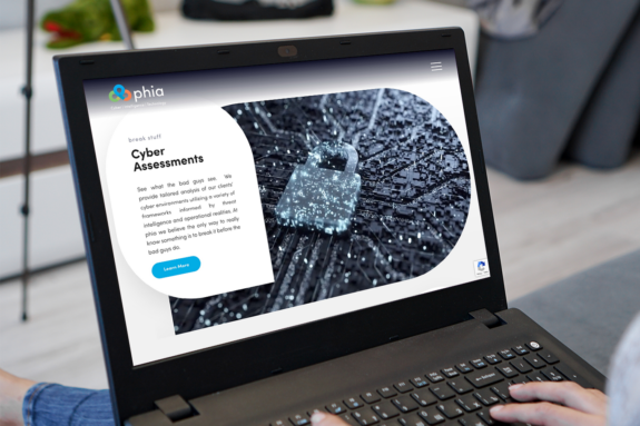A black motherboard with a lock is depicted on the new phia website and is shown on a laptop.
