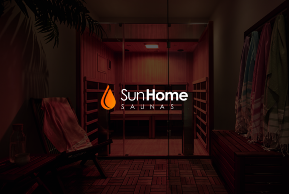 The new logo for Sun Home Saunas is imposed on a dark photo of a sauna.